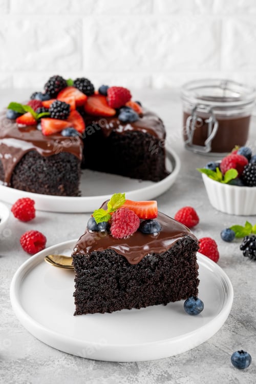 Preview: Delicious chocolate cake with chocolate glaze and fresh berries on a white plate