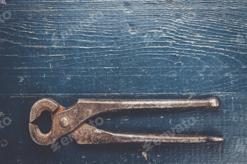 Preview: old rusty tongs on blue table
