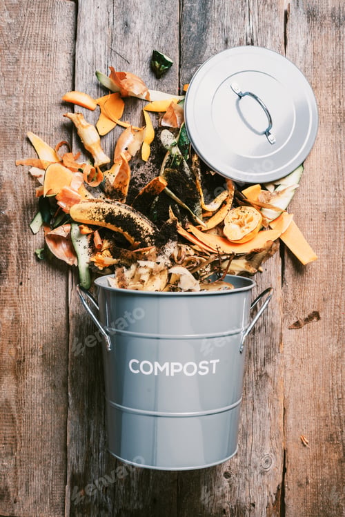 Preview: Garbage sorting. Organic food waste from vegetable ready for recycling in compost bin on wooden
