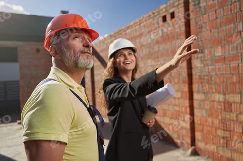Preview: Inspired construction engineer describing building project to builder