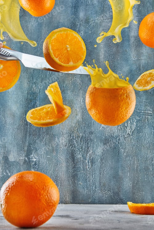 Preview: Freshly cut orange levitation. A knife cuts an orange.