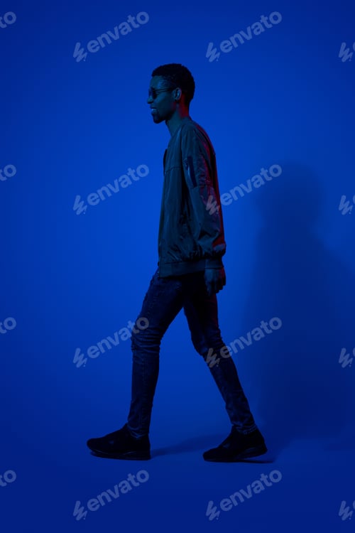 Preview: Stylish black guy walking in dark room