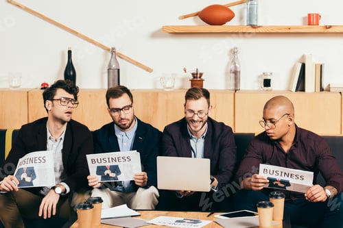 Preview: portrait of young multicultural businessmen with newspapers in cafe