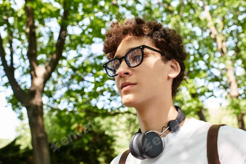 Preview: Young man enjoying a sunny afternoon in a lush green park