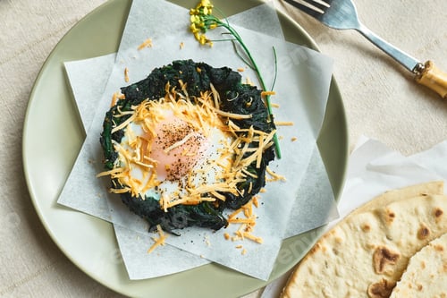 Preview: Easter breakfast idea. Baked spinach egg nests decorated with grated cheese and black pepper.