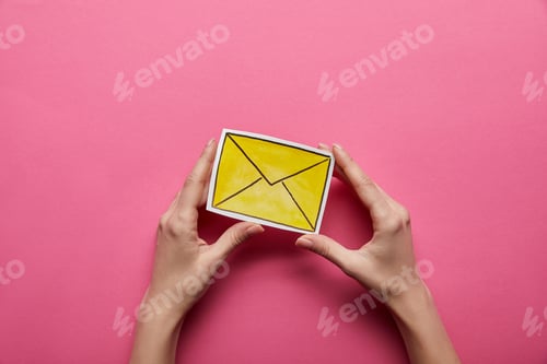 Preview: top view of yellow email sign on pink background