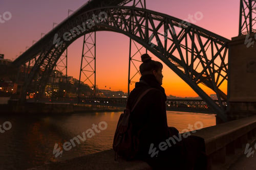 Preview: Woman looking at river and city in evening
