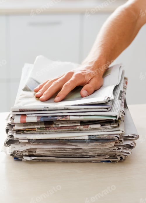 Preview: Ready to make something else. Cropped shot of a man with a stack of newspaper.