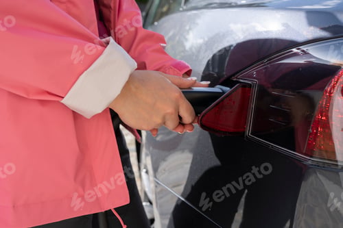 Preview: woman's hand charging electric car, environment concept ecology non-polluting transport