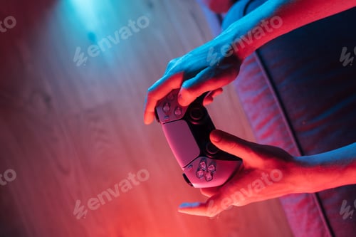 Preview: Man hands with game controller in neon light, top view