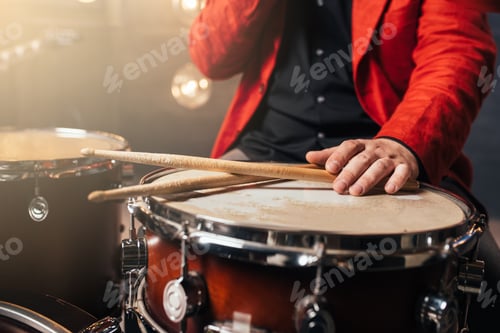 Preview: Male drummer in red suit sitting behind drum set