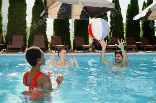 Preview: Smiling friends play with ball in the pool
