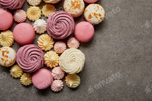 Preview: Top view of assorted delicious french macaroons with meringues on gray background