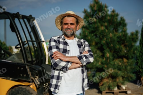 Preview: With forklift. Senior gardener is at work at daytime