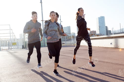 Preview: Portrait of group of friends running in the city.
