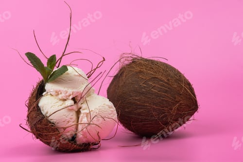 Preview: Vanilla ice cream balls in an empty coconut decorated with mint leaves on a pink background