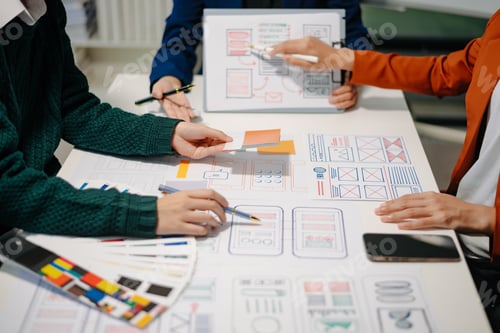 Preview: Close up view of UI developer team brainstorming on their project with laptop, smartphone and