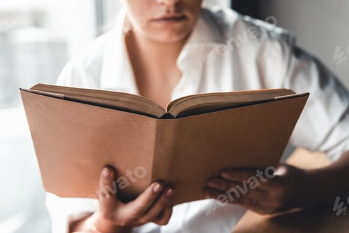 Preview: A woman is reading a book. Education, training, learning, hobby. Manicure