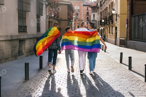 Preview: Joyful Back View: Four Gay Friends Embrace, Wearing LGBT Accessories, Walking in Sunlit City at Dusk