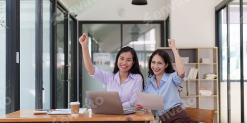 Preview: Two Smiling Women Celebrating Success at Office Desk
