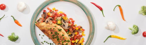 Preview: top view of yummy wrapped omelet with vegetables on plate with ingredients