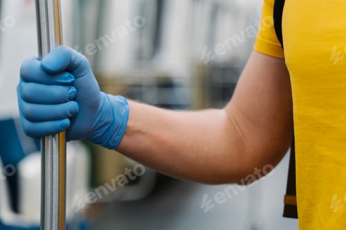 Preview: Protective rubber blue gloves touches handrail of metro prevents infection distribution