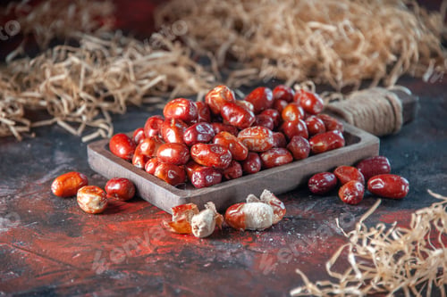 Preview: Side view of fresh raw silverberry fruits inside and out side of a wooden tray on mix colors