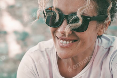 Preview: Closeup portrait of happy serene mid adult woman smiling and enjoying outdoor leisure activity