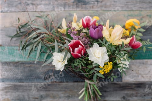 Colorful Bouquet with Tulips and Daffodils Against Wood