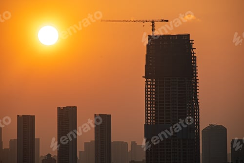 Preview: a tall building with a crane that is under construction behind it