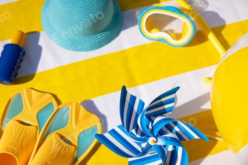 Preview: Beach accessories on yellow striped towel