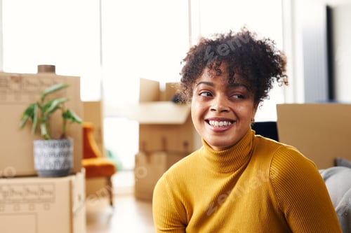 Preview: Portrait Of Young Woman Sitting On Floor And Smiling As She Moves Into New Home Surrounded By Boxes