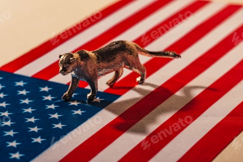 Preview: Golden toy tiger with shadow on american flag, animal welfare concept