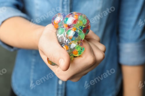 Preview: Woman squeezing colorful slime, closeup. Antistress toy