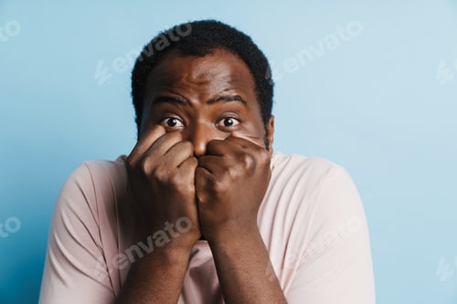 Preview: Black scared man in t-shirt posing with clenched fists
