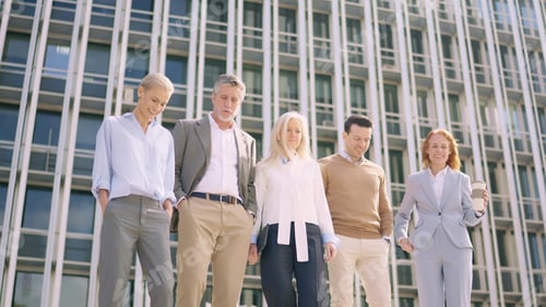 Preview: Business people walking down stairs in front of a building