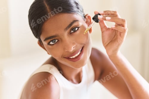 Preview: Smiling Woman Applying Facial Oil With Dropper At Home