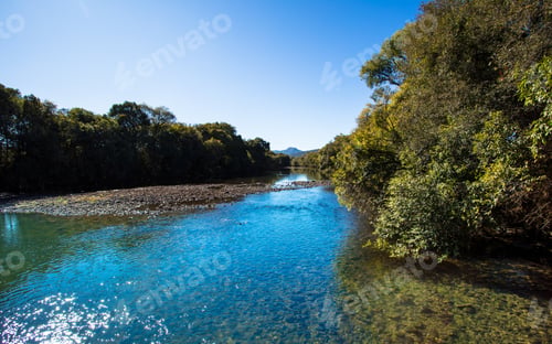Preview: Landscape with river bordered by forests.