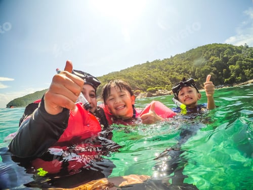 Preview: Happy family snorkelling in a tropical emerald sea