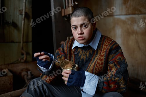 Preview: Hungry homeless castoff young woman eating canned food