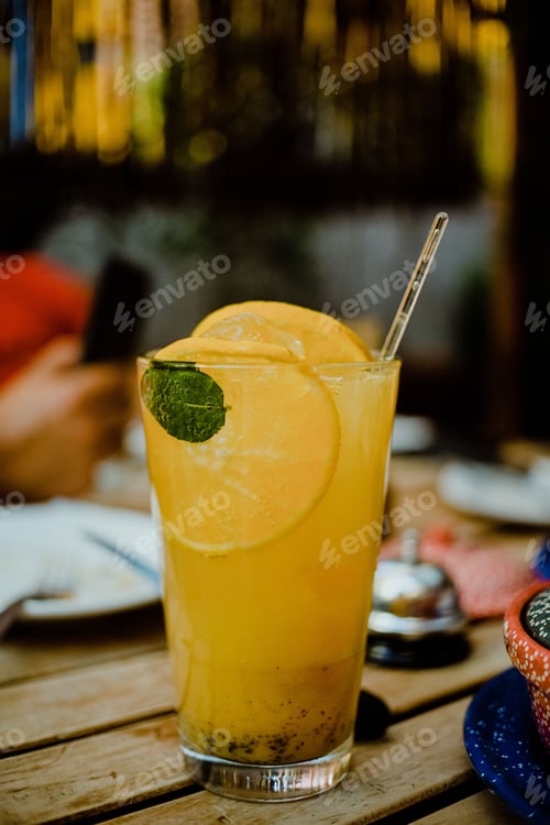 Preview: Refreshing beverage with orange slices served on a rustic wooden table