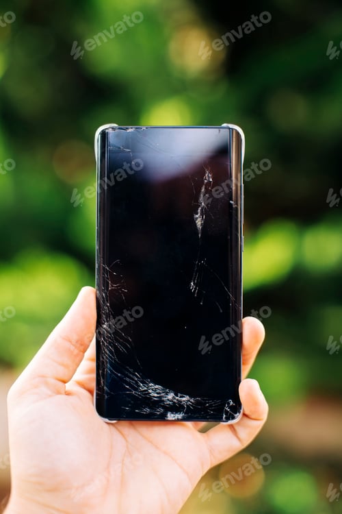 Preview: Woman's hand holding broken smartphone, close up