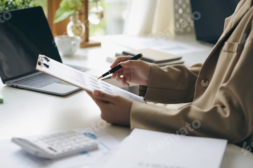 Preview: Business woman holding financial report analyzing and planning finances in home office.