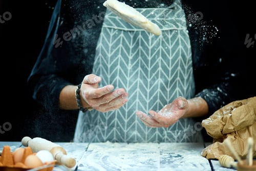 Preview: The man, chef cooks throws the dough, flying, freezing in motion.