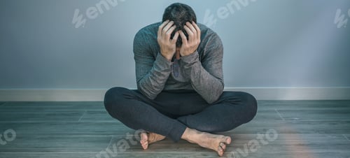 Preview: Man with problems covering face sitting on the floor