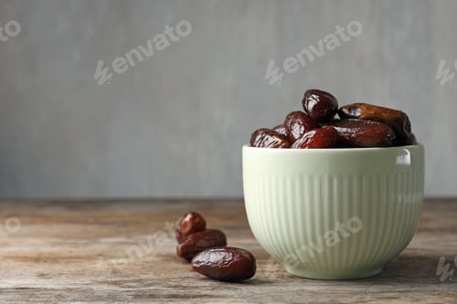 Preview: Bowl with sweet dates on table, space for text. Dried fruit as healthy snack