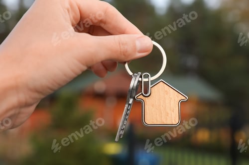 Preview: Woman holding house keys outdoors, closeup. Real estate agent