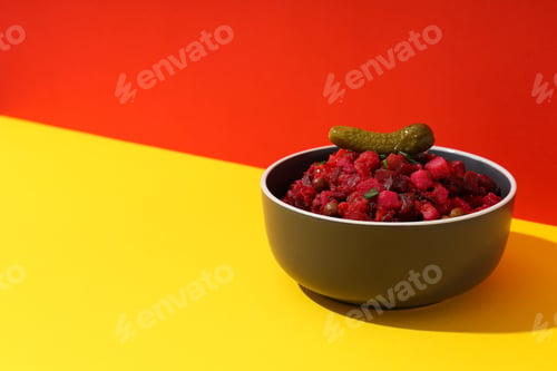 Preview: Salad vinaigrette in bowl on yellow table on red background, space for text