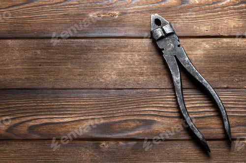 Preview: old rusty pliers on wooden background