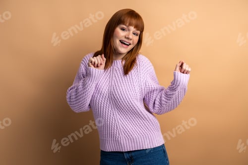 Preview: Cheerful Woman in Purple Sweater Dancing Indoors